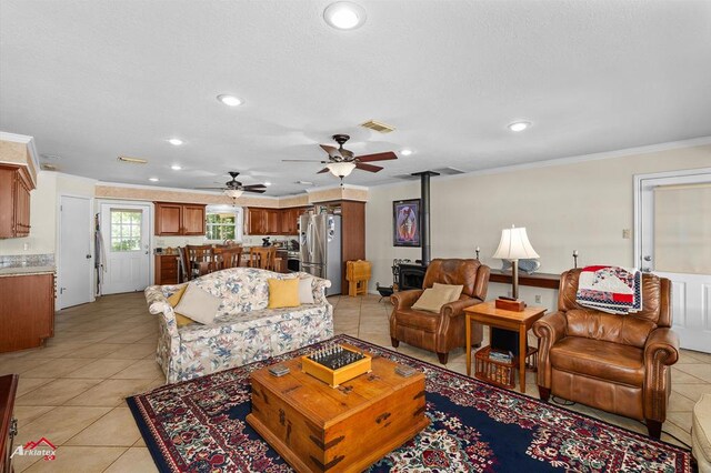 140 Eastwood Dr, Milam, TX 75959 - living area with recessed lighting, crown molding, a ceiling fan, light tile patterned floors, and a wood stove