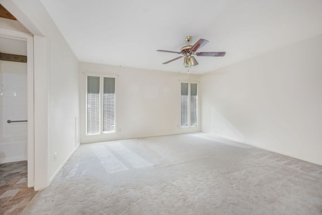 carpeted spare room featuring ceiling fan