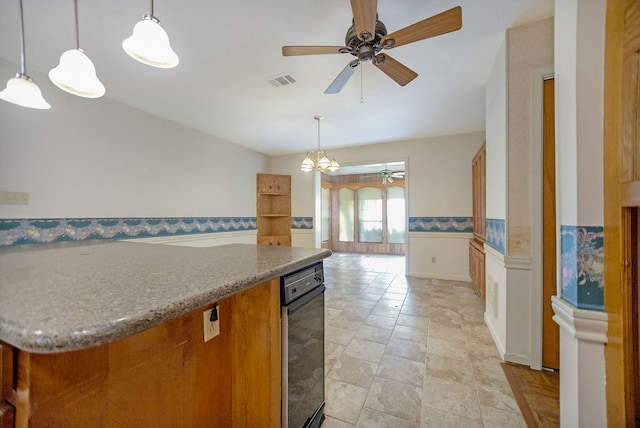 kitchen featuring stone counters, hanging light fixtures, and ceiling fan with notable chandelier