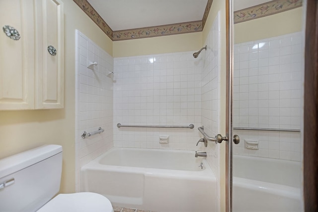 bathroom with tiled shower / bath combo and toilet