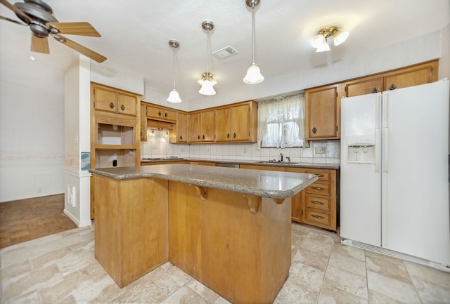 kitchen with sink, ceiling fan, white fridge with ice dispenser, decorative light fixtures, and cooktop