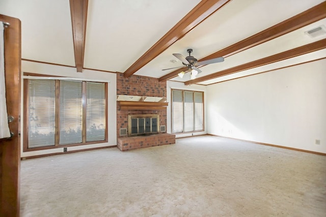 unfurnished living room featuring carpet flooring, beam ceiling, a brick fireplace, and ceiling fan