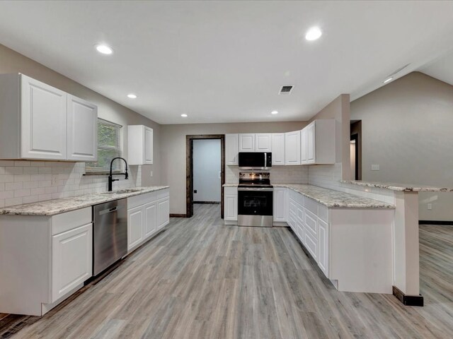 242 W Magnolia, Huntington, TX 75949 - kitchen featuring stainless steel appliances, light wood-style flooring, a sink, baseboards, and backsplash