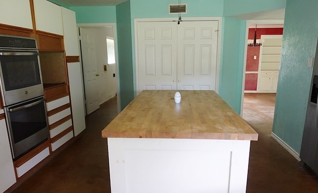 600 Daily St, Jasper, TX 75951 - kitchen featuring stainless steel double oven, white cabinetry, wood counters, and a center island