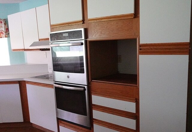 600 Daily St, Jasper, TX 75951 - kitchen featuring double oven, white cabinetry, light countertops, and ventilation hood