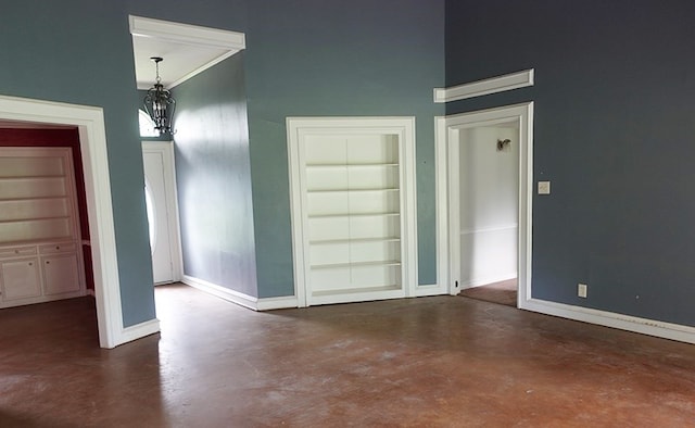 600 Daily St, Jasper, TX 75951 - unfurnished room with built in features, concrete flooring, a chandelier, and a towering ceiling