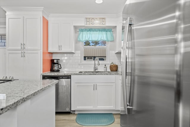 kitchen with sink, decorative backsplash, stainless steel appliances, and white cabinets