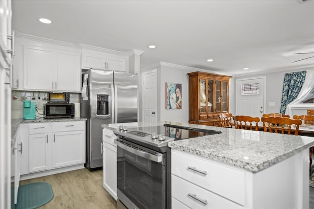 kitchen with white cabinetry, stainless steel appliances, light stone countertops, and light hardwood / wood-style flooring