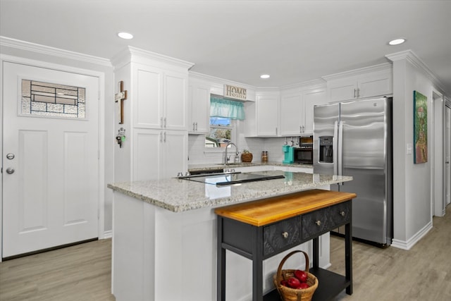 kitchen featuring a breakfast bar area, white cabinets, a center island, light stone counters, and stainless steel fridge with ice dispenser