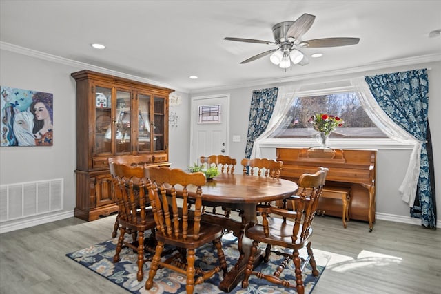 dining area featuring crown molding, a wealth of natural light, and light hardwood / wood-style floors