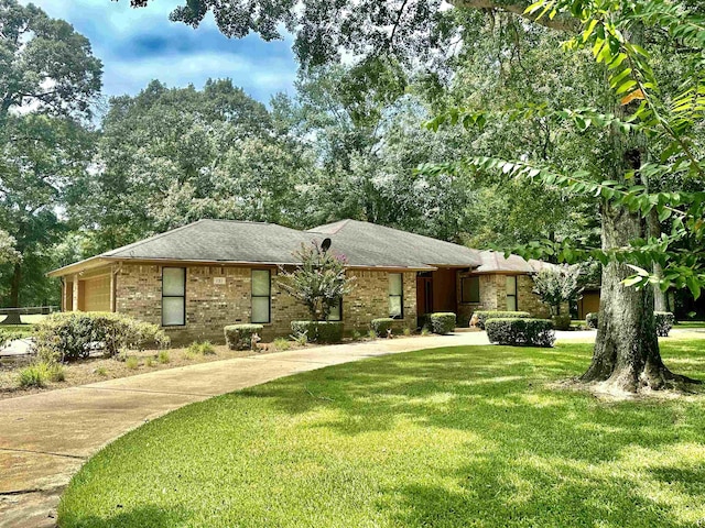 ranch-style house featuring a garage and a front lawn