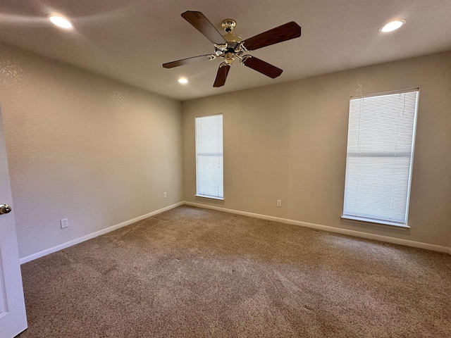 carpeted spare room with ceiling fan