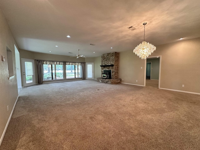 unfurnished living room with carpet, ceiling fan with notable chandelier, and a fireplace