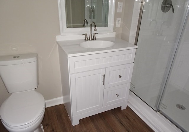 bathroom featuring hardwood / wood-style floors, vanity, toilet, and a shower with shower door