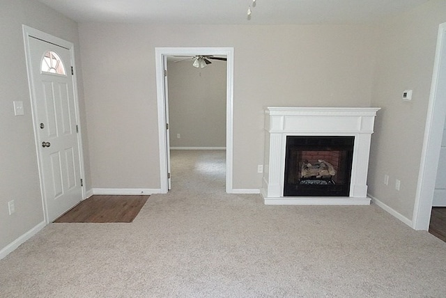 unfurnished living room with ceiling fan and light carpet