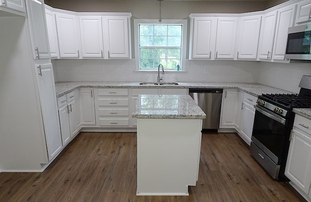 kitchen with dark hardwood / wood-style flooring, white cabinets, stainless steel appliances, and sink