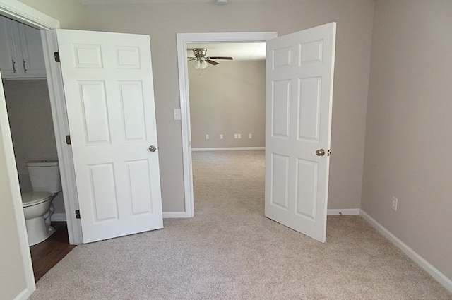 unfurnished bedroom featuring light carpet and connected bathroom