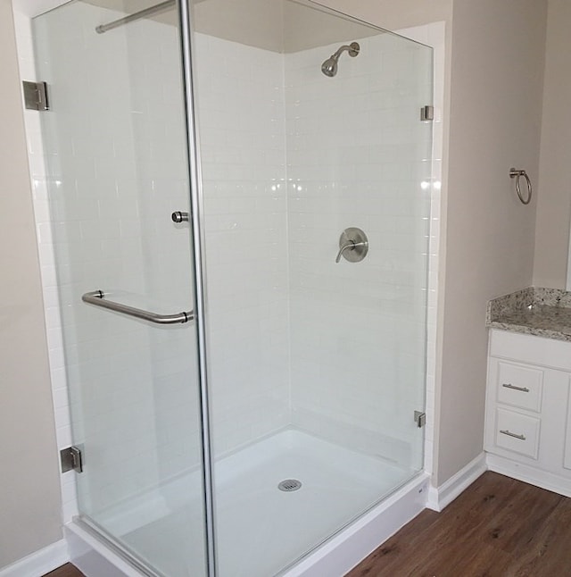 bathroom with hardwood / wood-style flooring and walk in shower