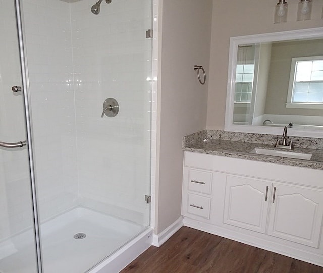 bathroom featuring a shower with door, wood-type flooring, and sink