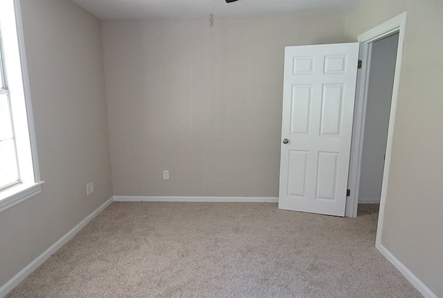 empty room with ceiling fan and light colored carpet