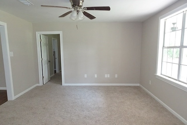 carpeted spare room with ceiling fan and a healthy amount of sunlight