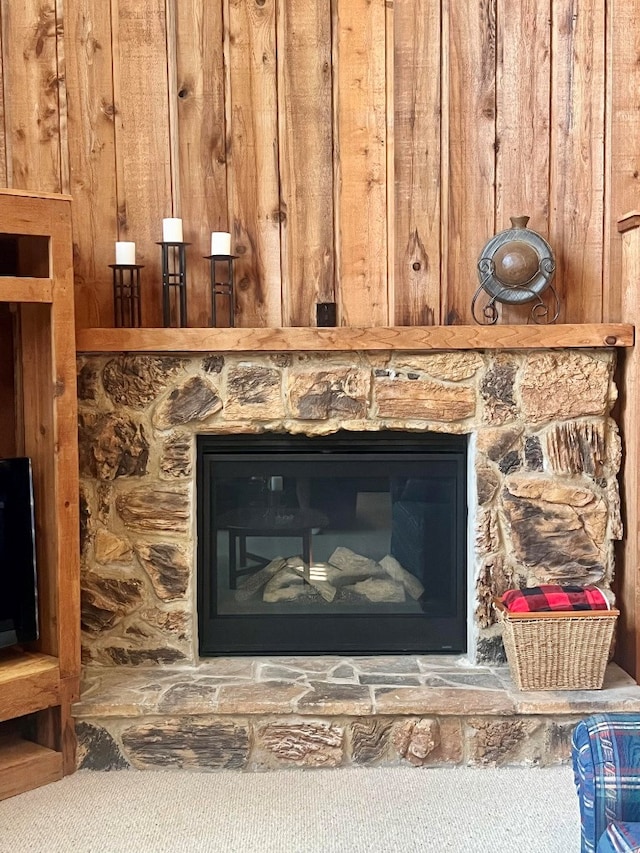 room details with carpet floors, wooden walls, and a fireplace