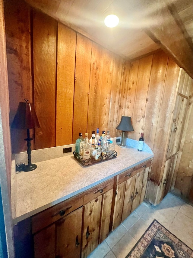 bathroom featuring tile patterned flooring and wooden walls