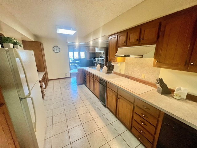 kitchen featuring under cabinet range hood, light tile patterned floors, white appliances, and light countertops