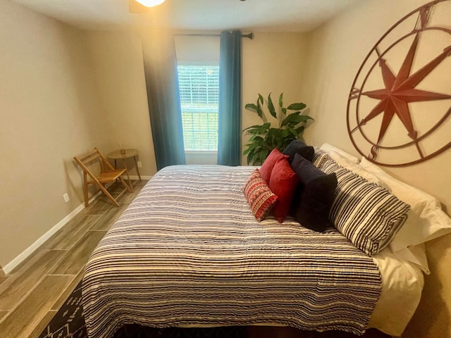 bedroom with baseboards and wood finish floors