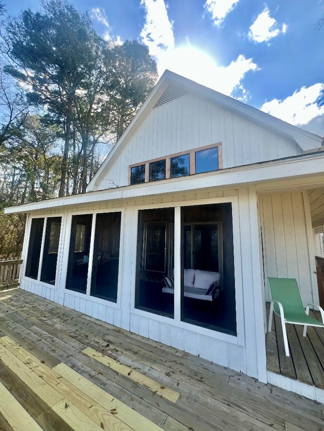 view of side of property with a wooden deck and a sunroom