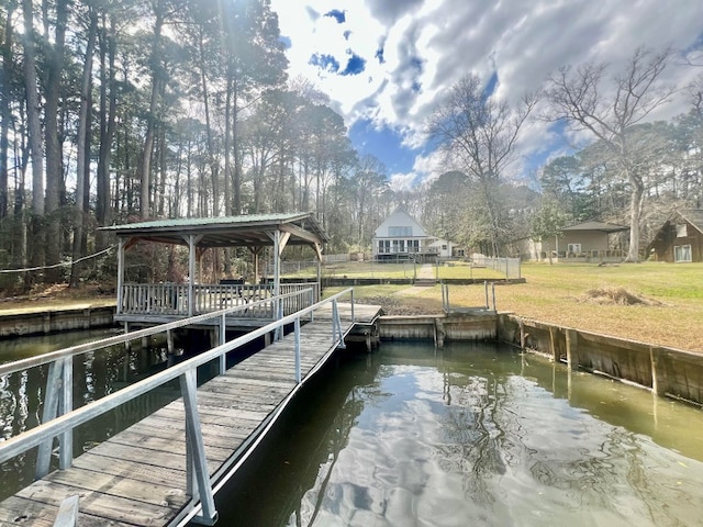 view of dock featuring a lawn and a water view