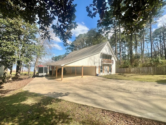 view of side of property with a lawn, driveway, and fence