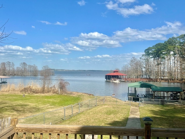 exterior space featuring fence, a yard, and a water view