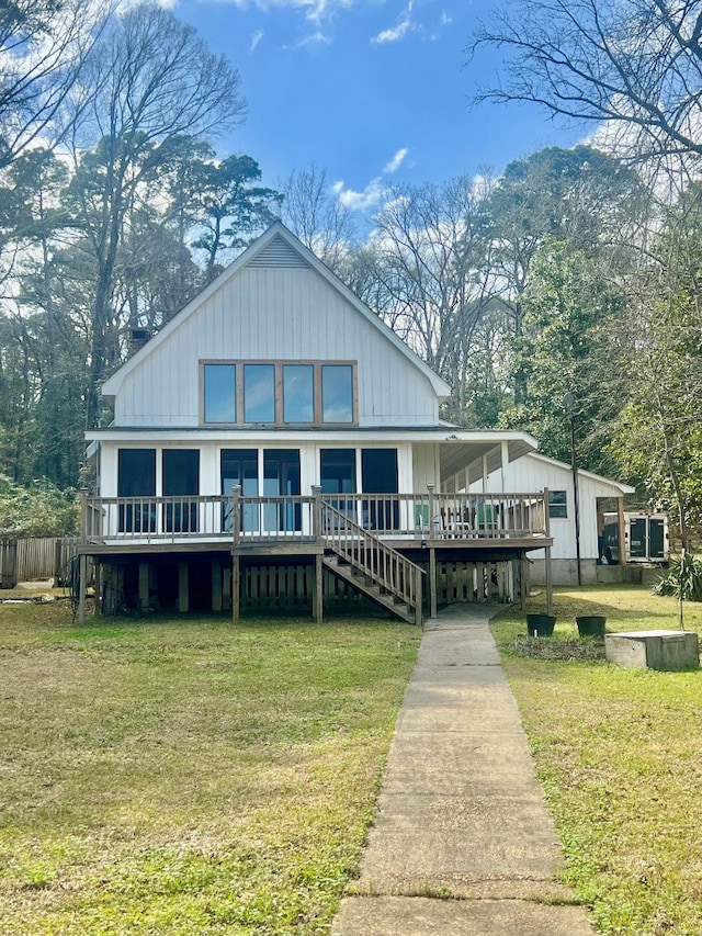 view of front of property with a deck and a front lawn
