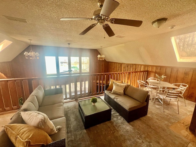 interior space with lofted ceiling, ceiling fan with notable chandelier, and a textured ceiling