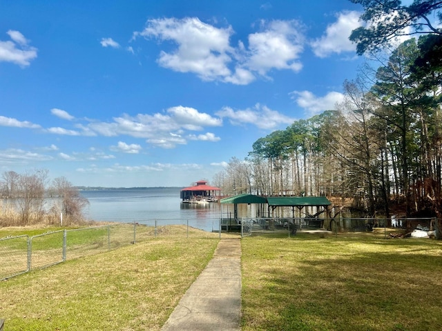 dock area featuring a lawn, fence, and a water view