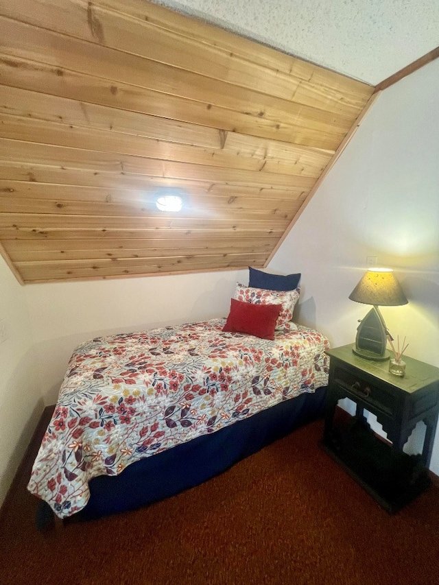 bedroom featuring carpet, vaulted ceiling, and wood ceiling
