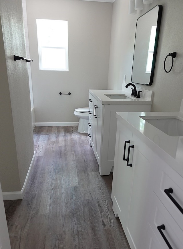 1604 Lilac Ave, Lufkin, TX 75901 - bathroom featuring vanity, toilet, wood finished floors, and baseboards