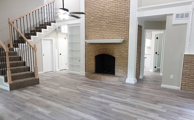 1604 Lilac Ave, Lufkin, TX 75901 - unfurnished living room featuring wood finished floors, stairs, ceiling fan, a towering ceiling, and baseboards