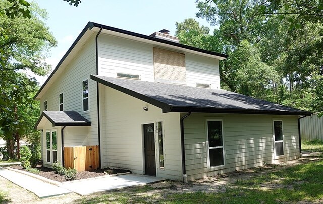 1604 Lilac Ave, Lufkin, TX 75901 - back of house featuring a chimney and roof with shingles