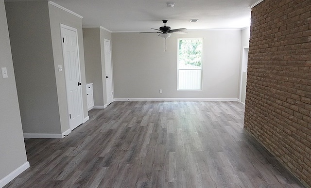 1604 Lilac Ave, Lufkin, TX 75901 - empty room with wood finished floors, ceiling fan, crown molding, baseboards, and brick wall