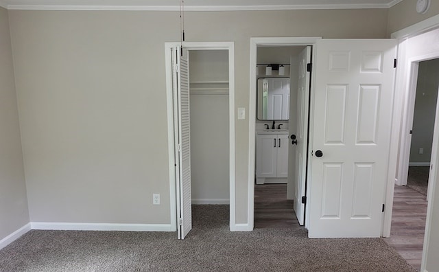 1604 Lilac Ave, Lufkin, TX 75901 - unfurnished bedroom featuring ornamental molding, a sink, baseboards, and dark carpet
