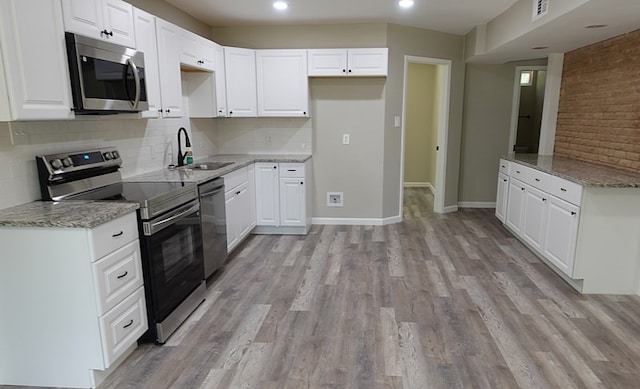 1604 Lilac Ave, Lufkin, TX 75901 - kitchen with stainless steel appliances, a sink, light stone counters, tasteful backsplash, and recessed lighting