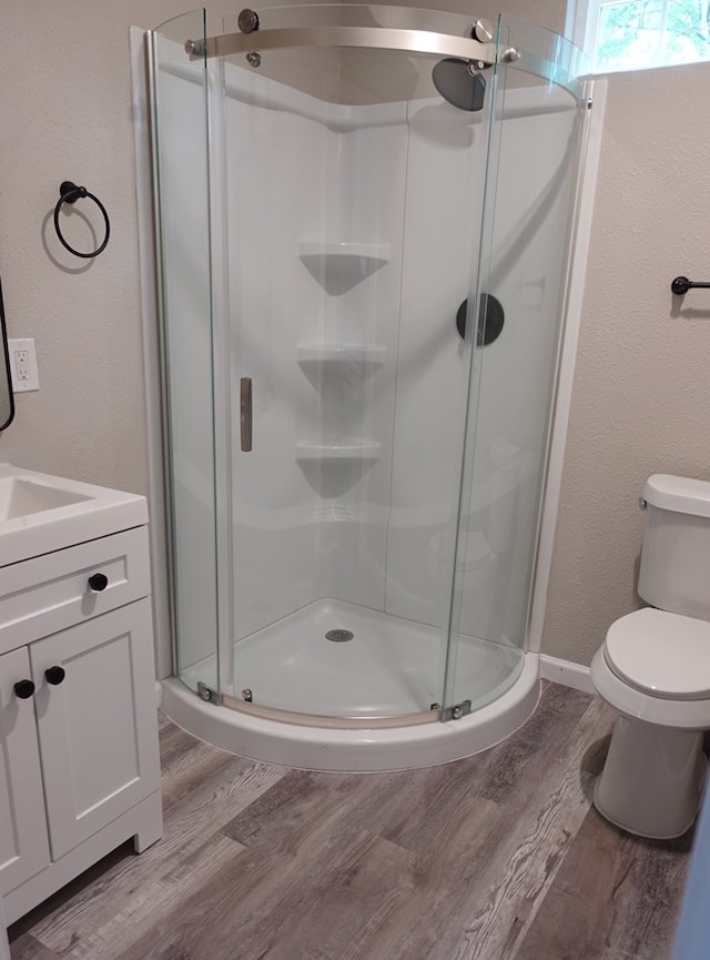 1604 Lilac Ave, Lufkin, TX 75901 - bathroom with wood finished floors, a stall shower, vanity, toilet, and baseboards