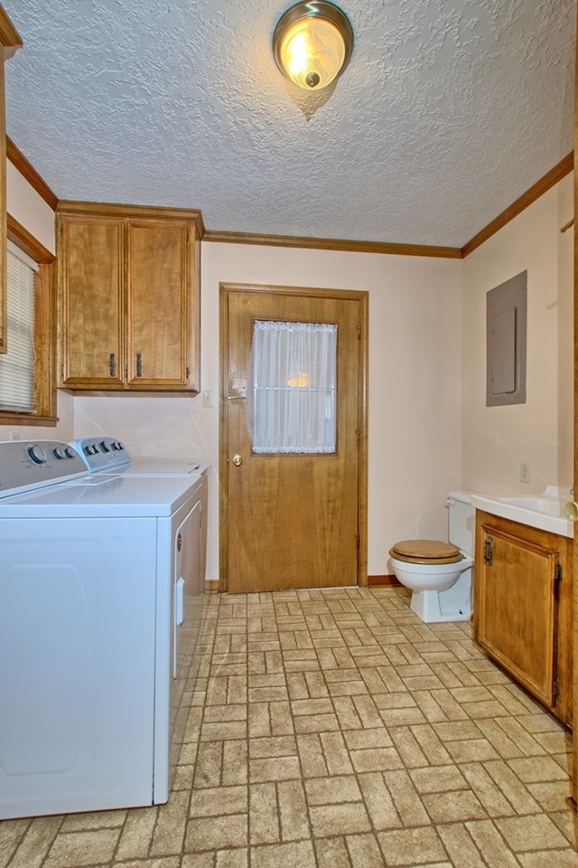 laundry area featuring washing machine and dryer, electric panel, and crown molding