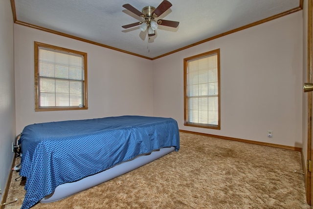 carpeted bedroom featuring multiple windows, ceiling fan, and ornamental molding