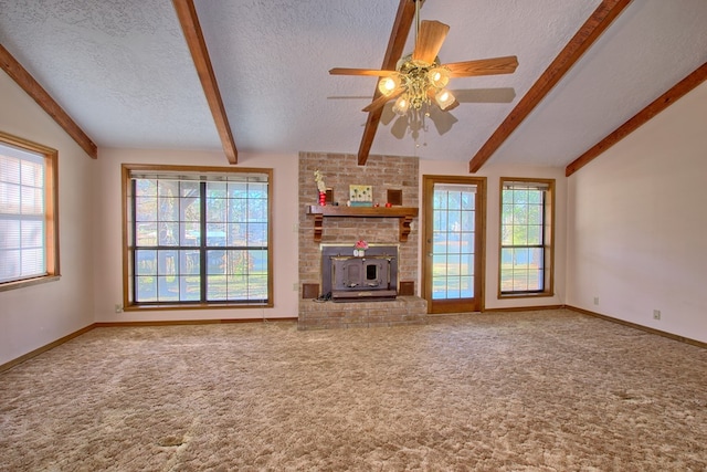 unfurnished living room featuring a wood stove, vaulted ceiling with beams, ceiling fan, a textured ceiling, and carpet floors