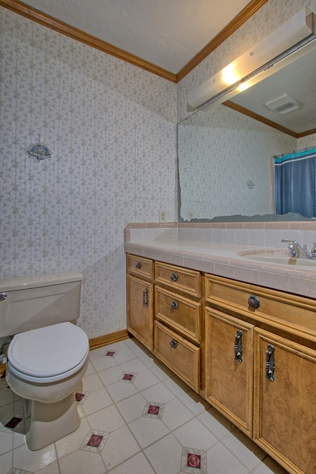 bathroom featuring vanity, tile patterned floors, crown molding, toilet, and a textured ceiling