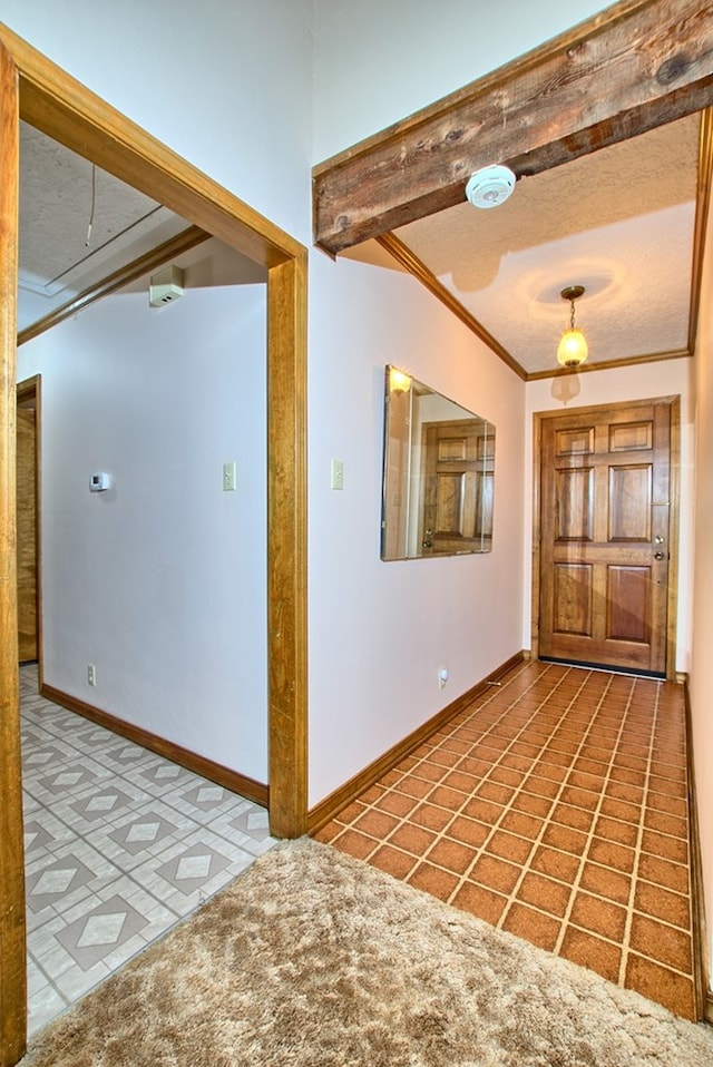 entryway featuring tile patterned floors, beam ceiling, ornamental molding, and a textured ceiling