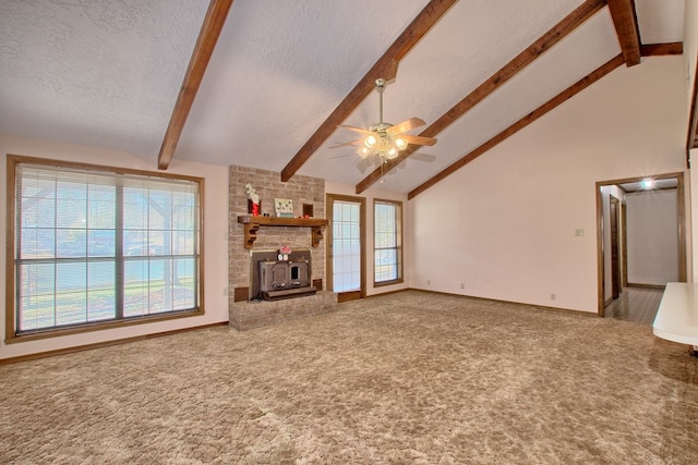 unfurnished living room with a wood stove, ceiling fan, and beamed ceiling